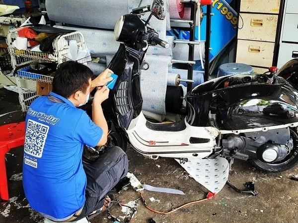 A worker applying a decal to an electric vehicle