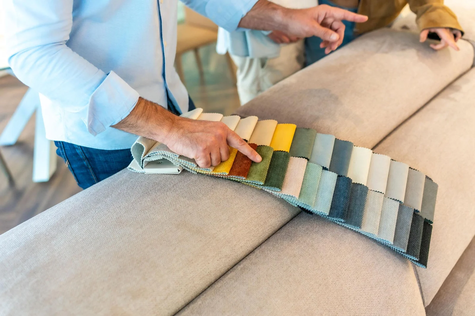 Upholstery swatches being compared against a sofa
